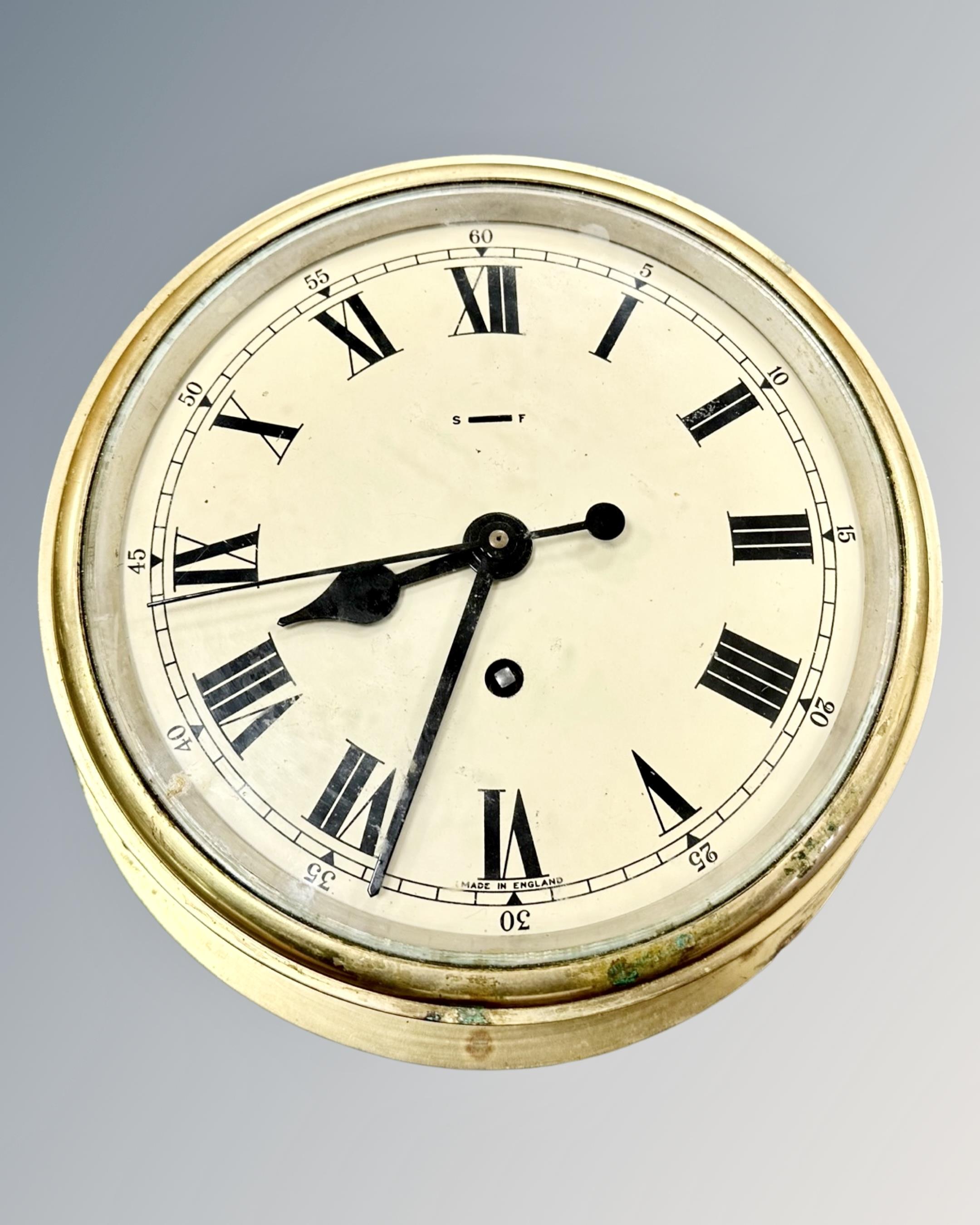 A brass circular cased wall timepiece, diameter 25cm.