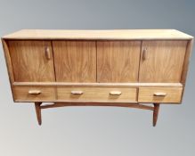 A 20th century teak low sideboard fitted with cupboards and drawers.