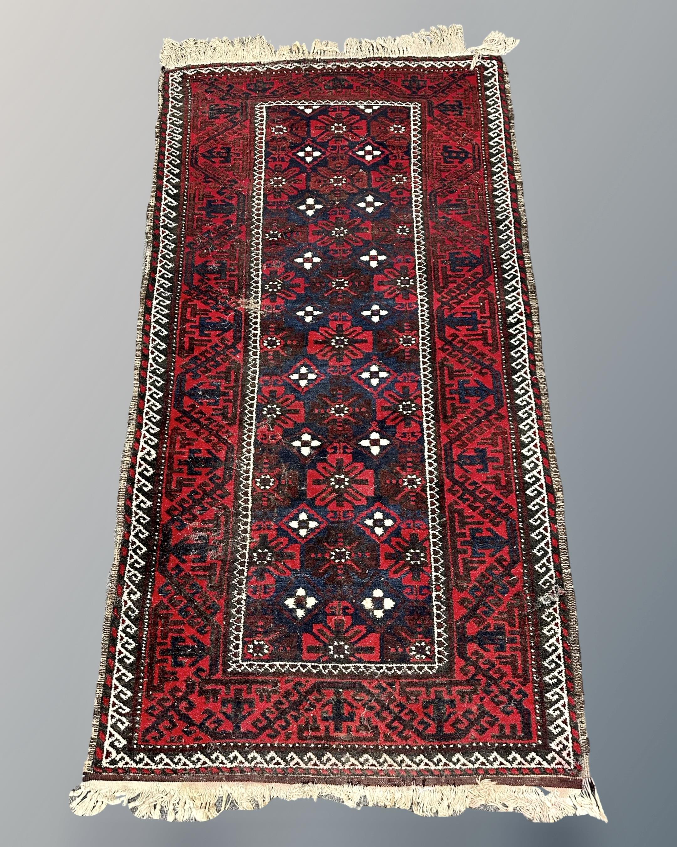 An Afghan rug, 92cm by 187cm.