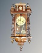 A late 19th century 8-day wall clock with pendulum and key.