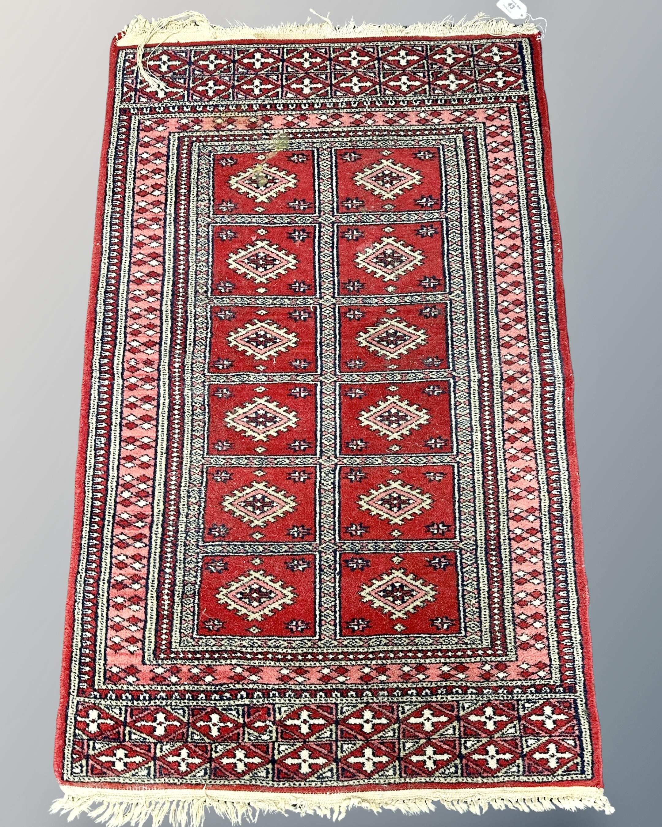 A Tekke design rug, 64cm by 103cm.