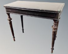 A 19th century D-shaped ebonised tea table on turned legs.