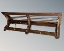 A rustic pine wall mounted coat rack with shelf