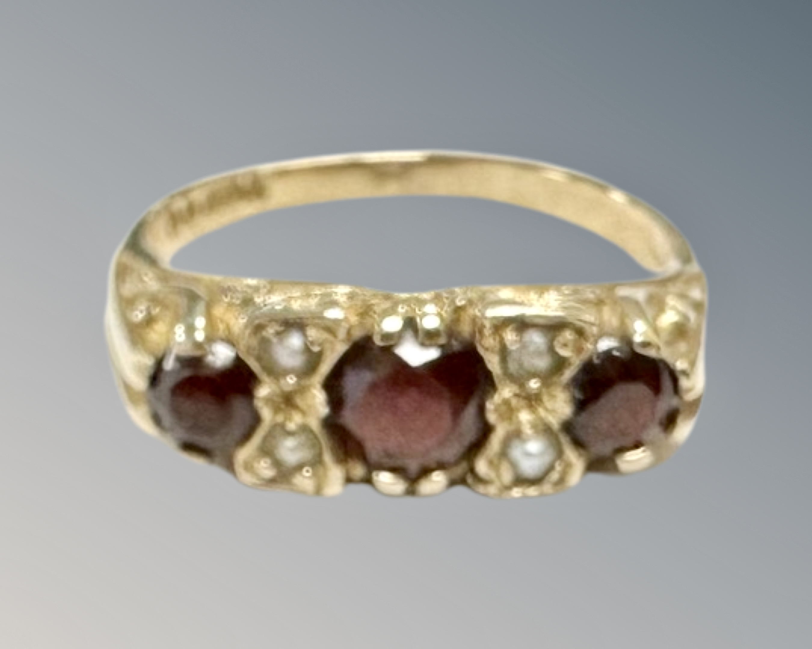 A 9ct yellow gold garnet and seed pearl ring, size L, 2.9g.