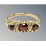 A 9ct yellow gold garnet and seed pearl ring, size L, 2.9g.