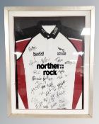A Newcastle Falcons rugby jersey bearing signatures in frame