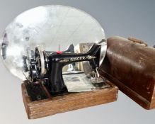 A vintage Singer sewing machine in case together with a frameless bevelled mirror