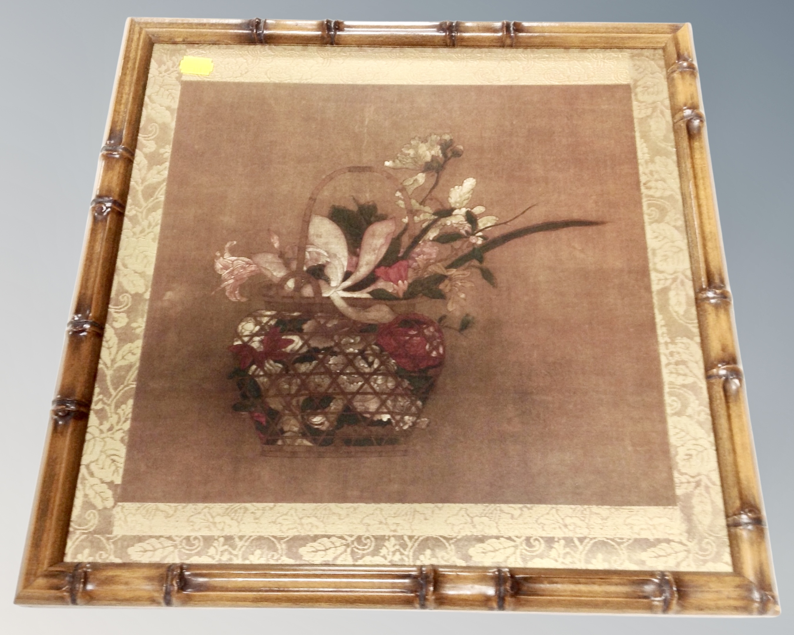 A Japanese style print depicting a basket of flowers in faux bamboo frame