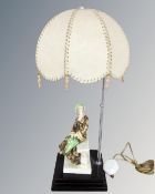 A 1930's porcelain figural table lamp with shade on wooden stand