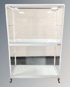 A Porsa two tier shop display cabinet on castors,