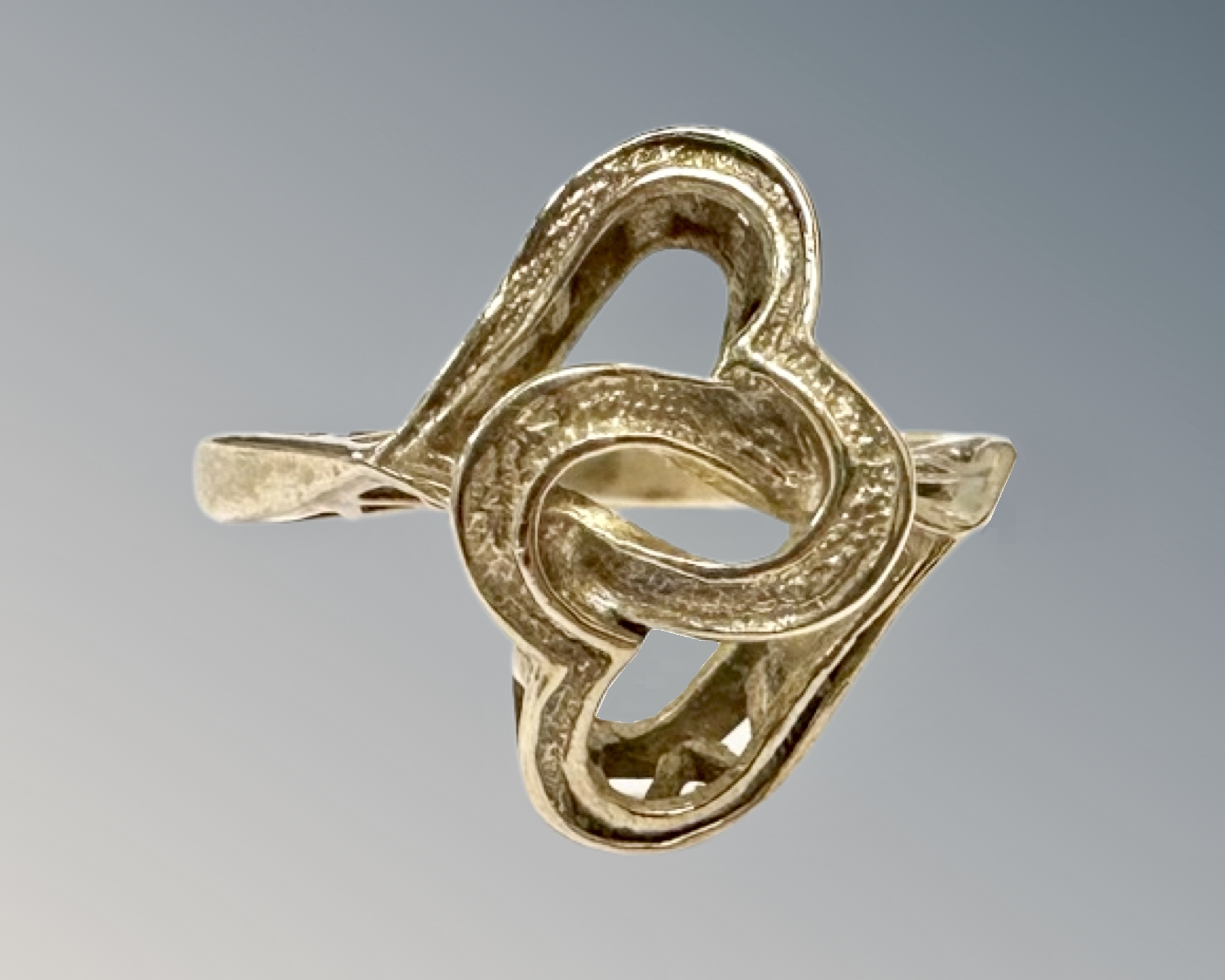 A 9ct yellow gold interlocking heart ring, 2.4g, size J/K.