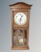 An Edwardian oak eight day wall clock with silvered dial,