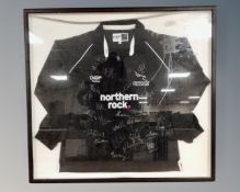 A Newcastle Falcons rugby jersey bearing signatures in frame