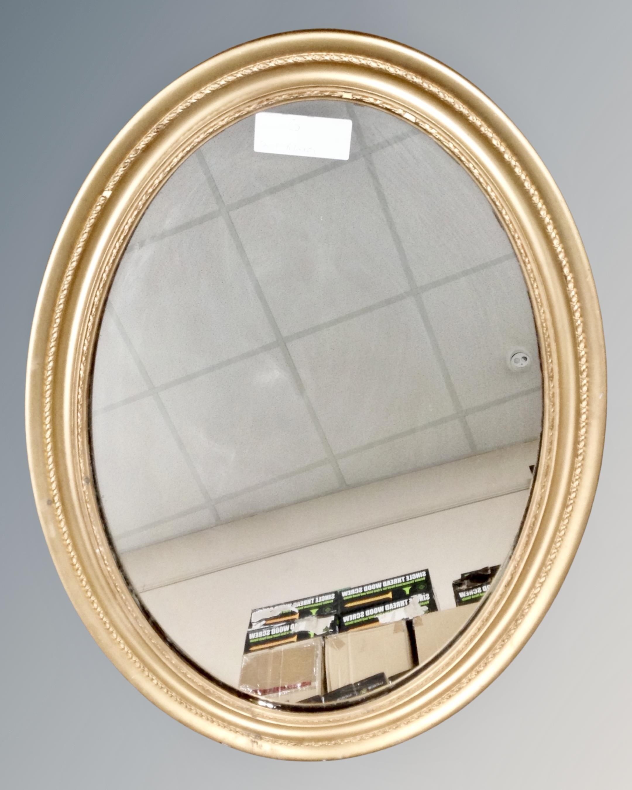An antique oval gilt framed mirror