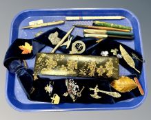 A collection of badges and brooches, lacquered Oriental pen box, silver propelling pencil,