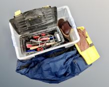A plastic crate containing tool box and tools, waterproof coat, trousers,