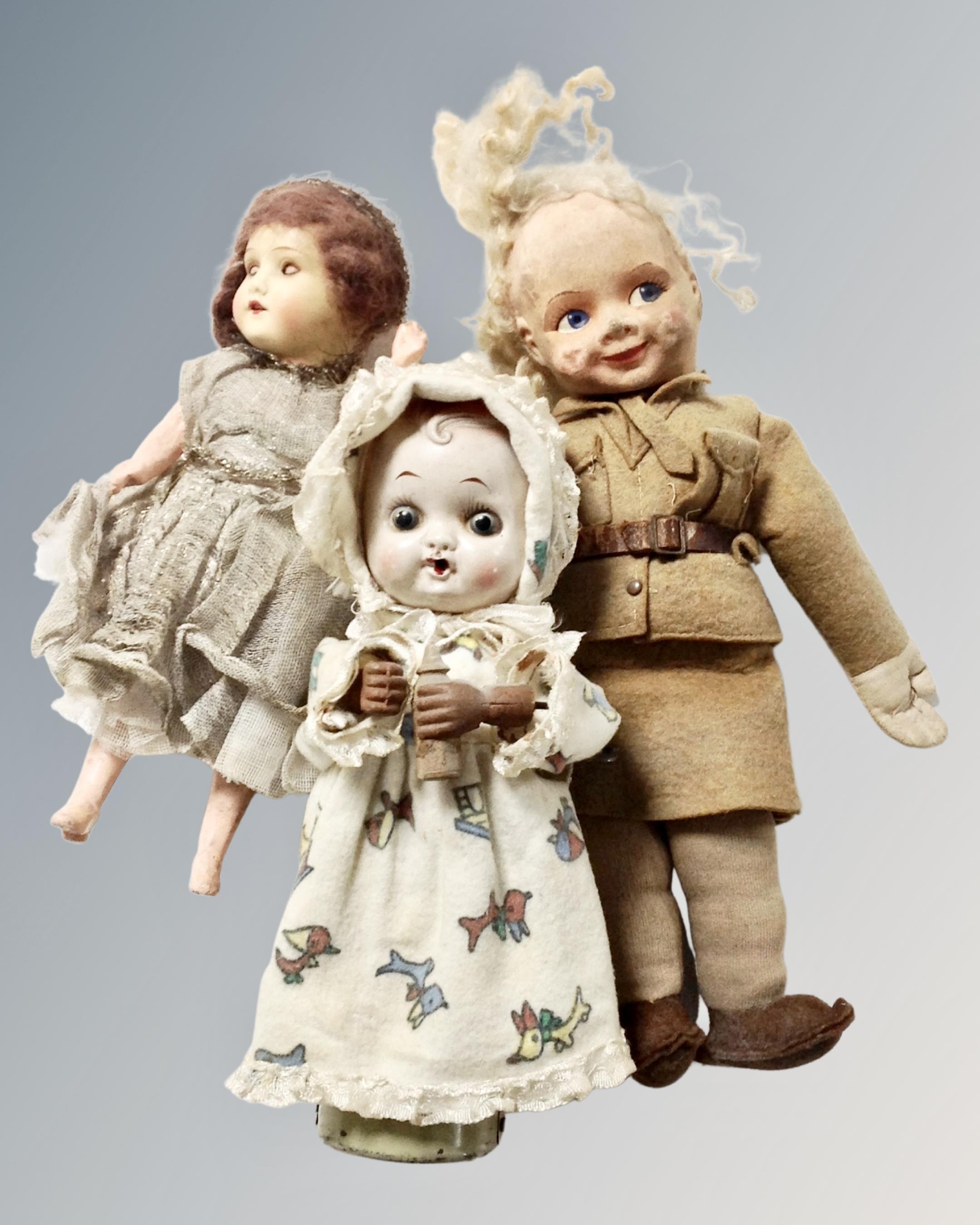 A vintage Japanese doll with key with two further vintage dolls