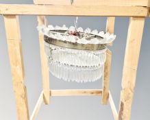 A vintage light fitting with glass drops in hanging pine crate