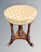A Victorian mahogany circular adjustable stool on tripod legs