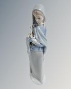 A Lladro china figure : Lady Holding Lillies, 23 cm.