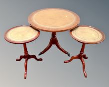 A reproduction mahogany pedestal occasional table with tooled leather inset panel,