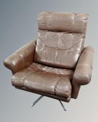 A Scandinavian brown button leather armchair on chrome swivel base
