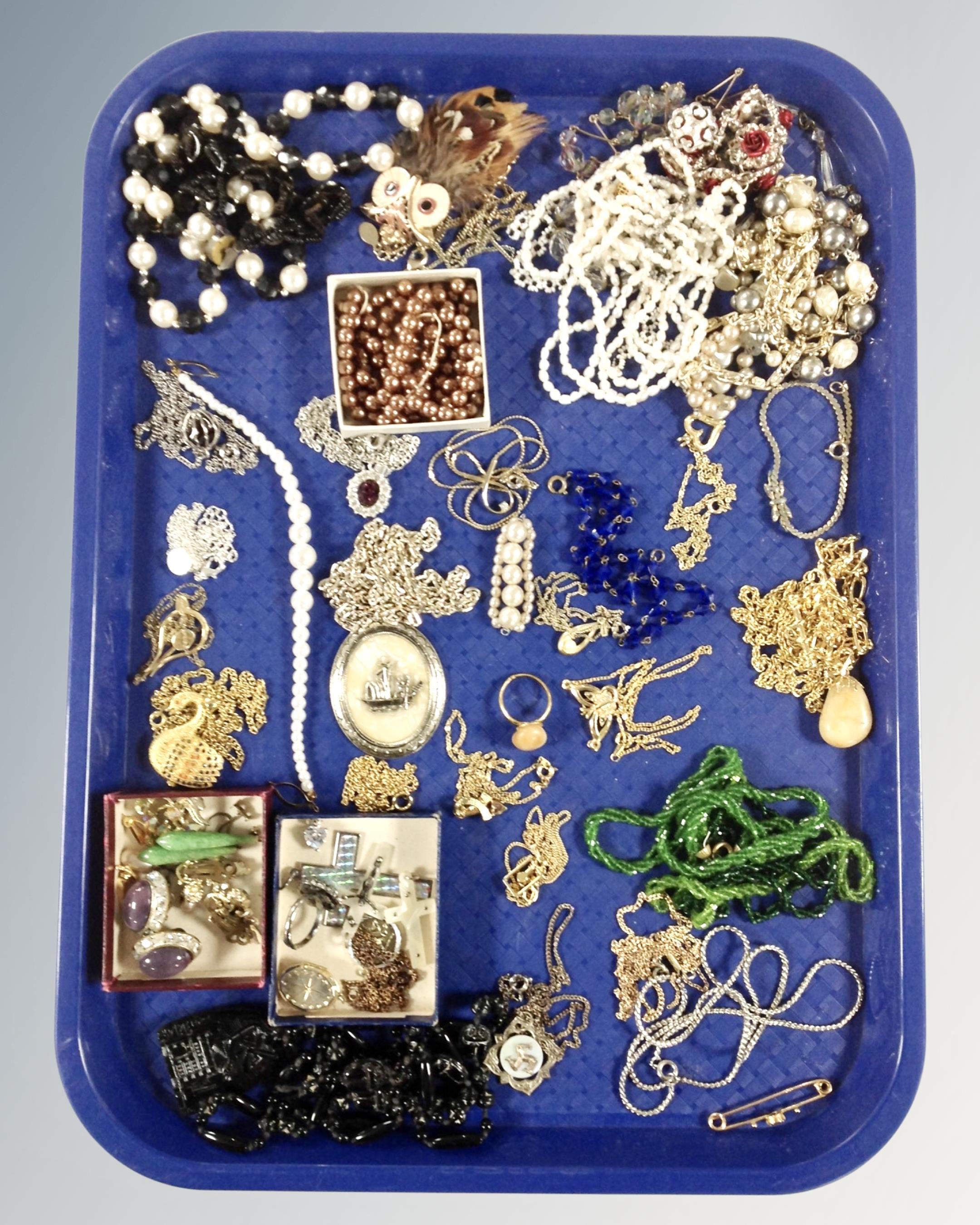 A tray containing costume jewellery including gilt and beaded necklaces, pendants on chains,