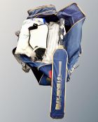 A cricket bag containing cricket bat, pads and shoes.