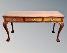 A Victorian style mahogany three drawer console table on claw and ball feet