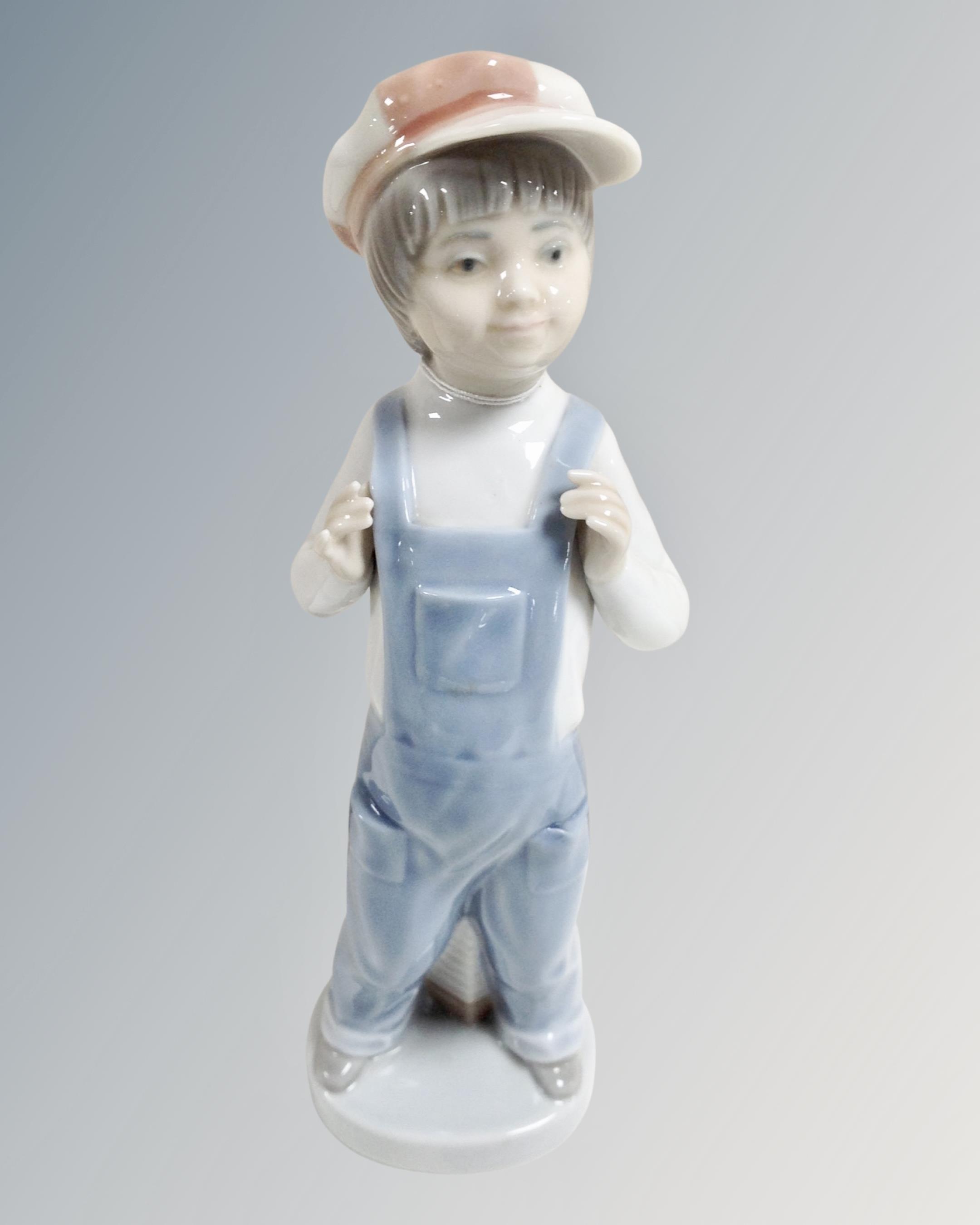A Lladro china figure : Young Boy Wearing Denim Dungarees, height 22 cm.