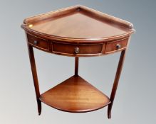 A reproduction mahogany two tier corner table fitted with a drawer.