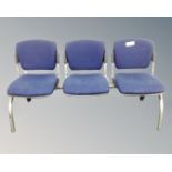 A metal framed triple section fixed seat upholstered in a blue fabric.