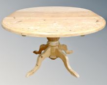 A circular pine farmhouse pedestal dining table with leaf