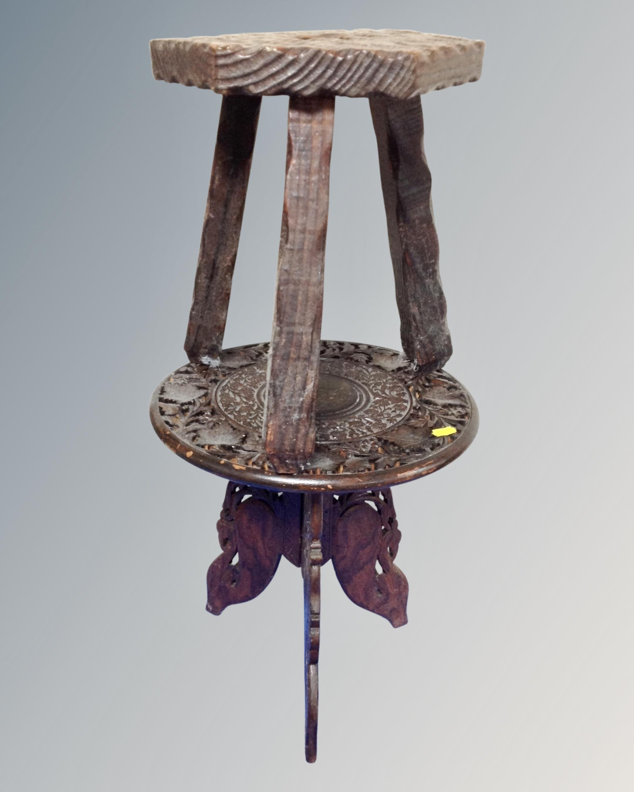 A carved Asian hardwood occasional table together with a rustic pine milking stool