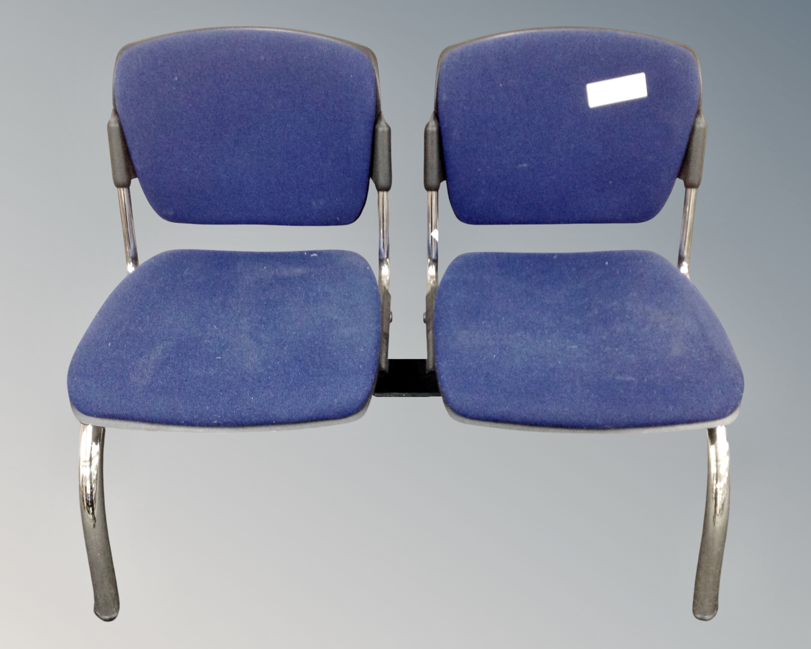 A metal framed double section fixed seat upholstered in a blue fabric.