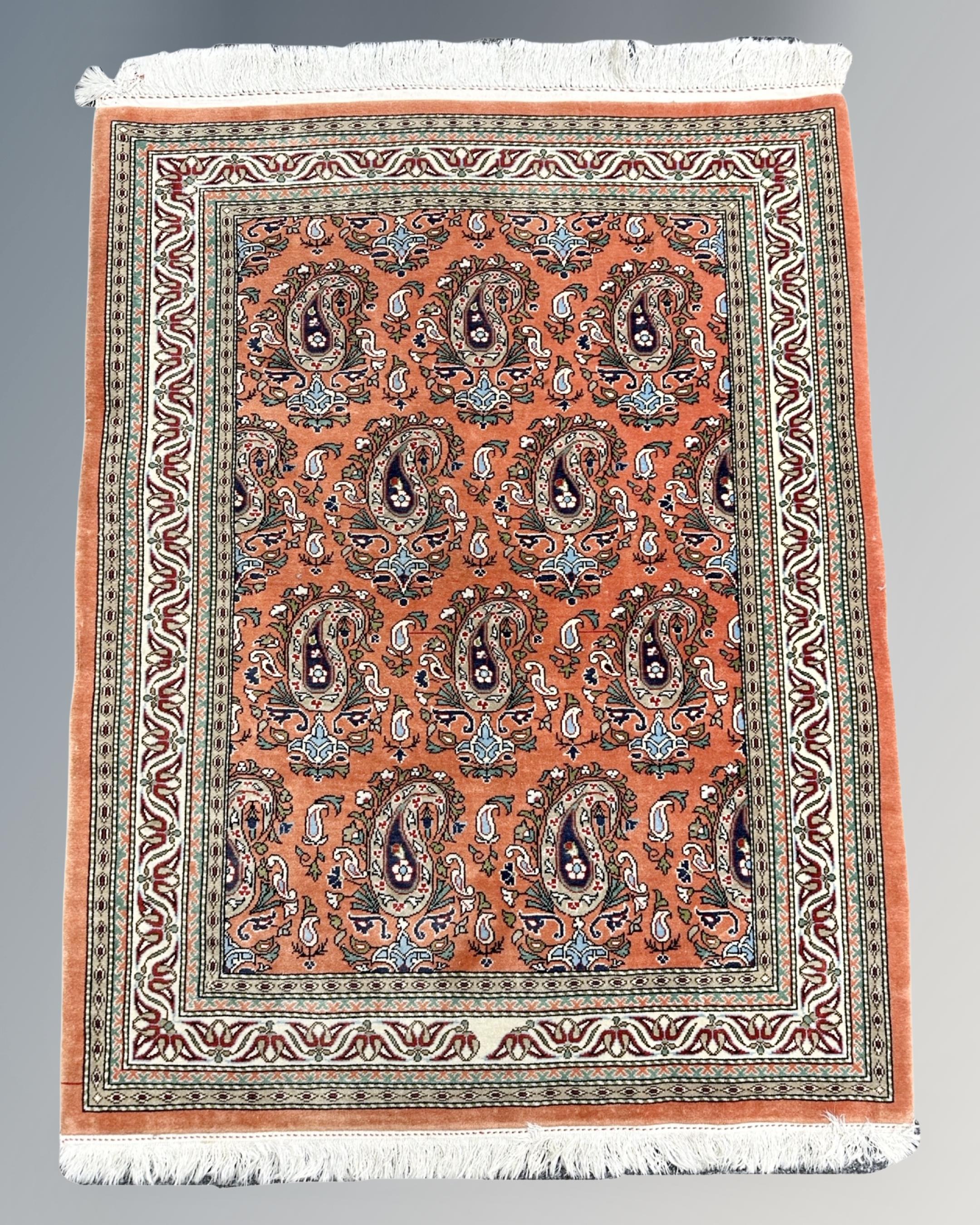 A finely woven Ghom rug, Central Iran, on salmon ground,