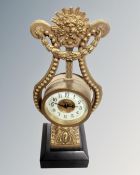 A decorative Victorian brass clock on black slate base.
