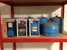 Four camping gas canisters together with four further Lumogaz camping gas lights,