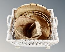 A large wicker log basket on wheels together with assorted wicker baskets