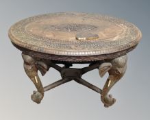 An Indian carved hardwood oval occasional table on elephant supports (a/f)