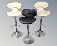 Three contemporary gas lift bar stools (two cream one black)