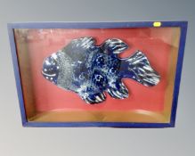 A blue and white pottery fish plaque in display case, width 66 cm.