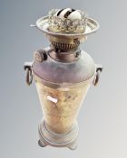 An antique brass twin handled vase with inset Duplex oil lamp base