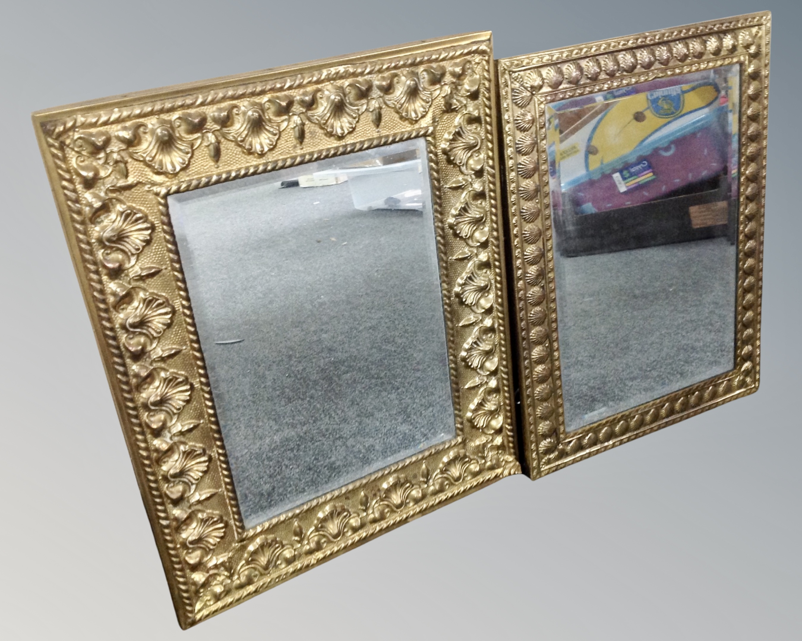 Two vintage brass embossed framed mirrors