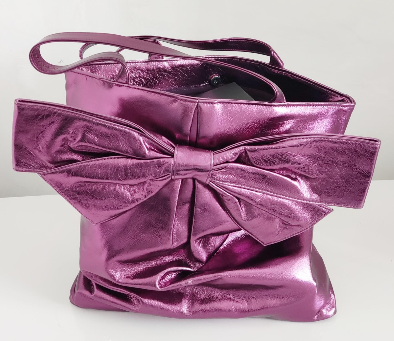 Nina Ricci shopping bag: shimmering carrier with popper fastening, detailed with a large bow.