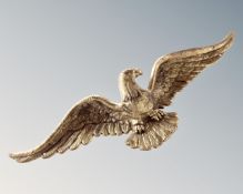 A brass figure of an eagle with wings spread.