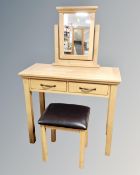 A contemporary oak two drawer dressing table on raised legs with mirror and stool