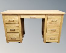 A contemporary oak twin pedestal seven drawer dressing table