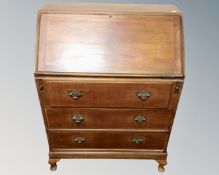 A 20th century Queen Anne style writing bureau fitted with three drawers
