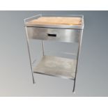 A stainless steel medical two tier trolley fitted a drawer with pine chopping board inset